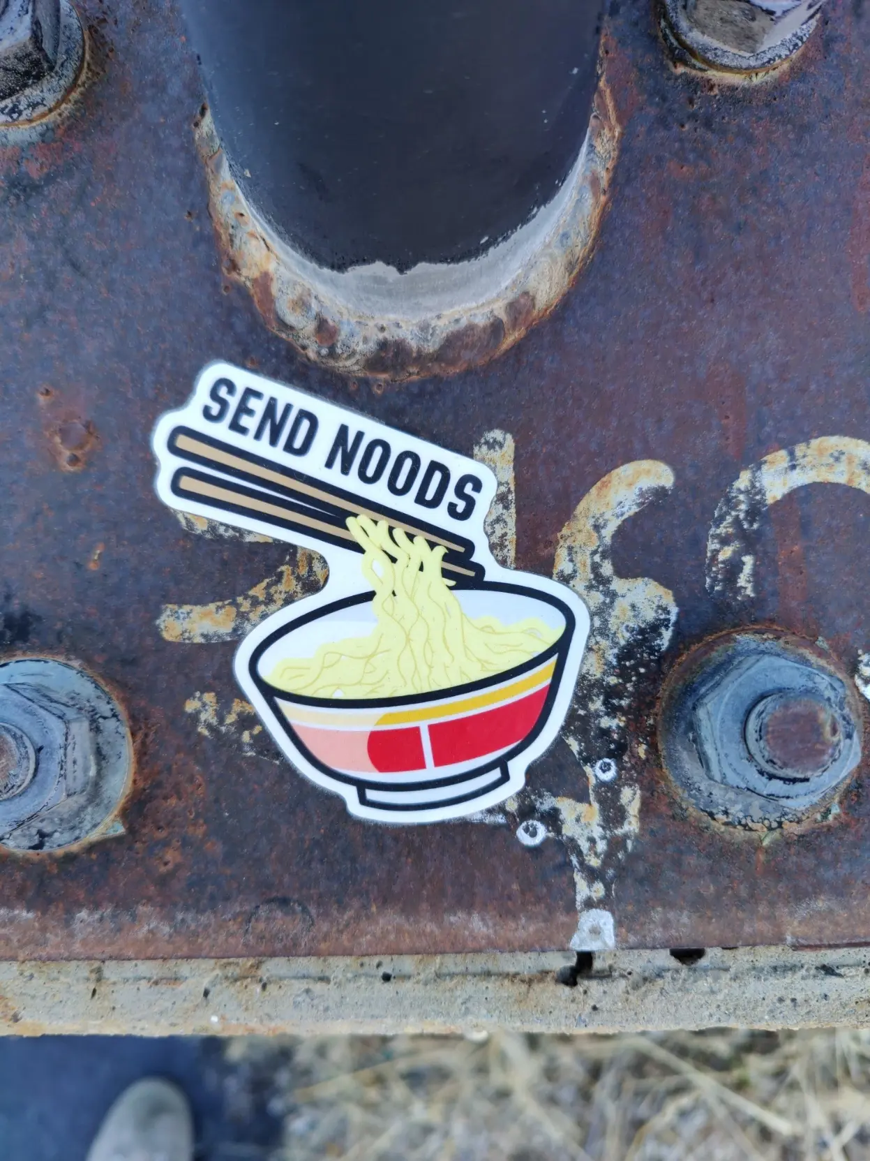 sticker with an illustration of ramen noodles in a bowl being picked up by chopsticks, text that reads "send noods"