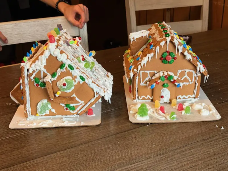 Two gingerbread houses, one (left) looks like its upsidedown and has people sledding on it, and snow sliding down the sides

the other (right) looks fairly normal, very well designed as a house