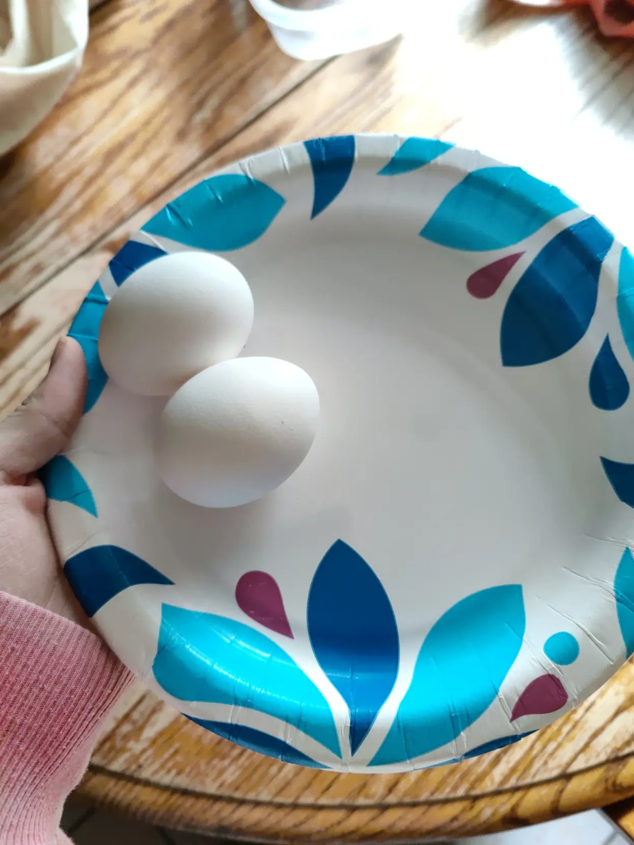 me holding a paper plate, with two completely uncracked eggs